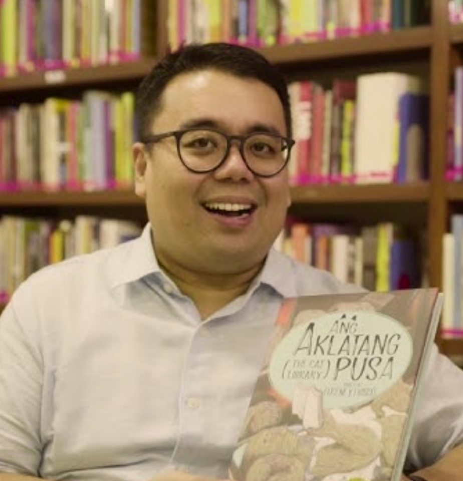 Eugene Evasco in a library holding a book